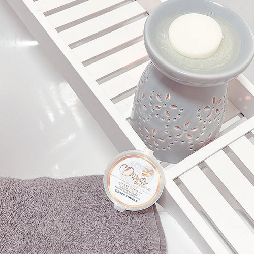 Grey floral wax warmer with white melt on shelf; blog tips on extending wax melt fragrance.