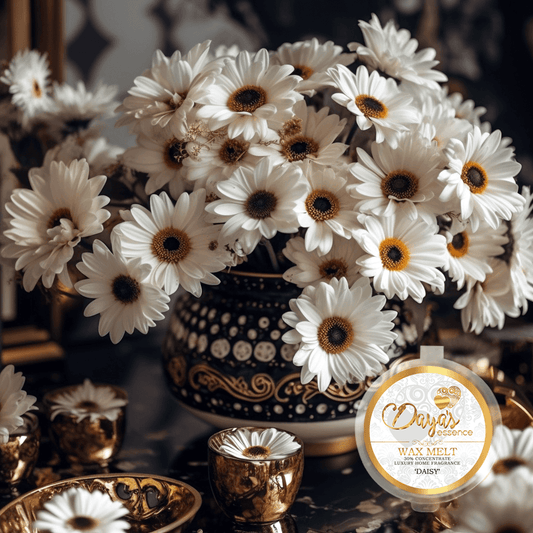 A 1oz tub with a sticker displaying the scent name "Daisy " Dayas Essence, 30% concentrated wax melt. Positioned at the bottom right, the tub is against a backdrop that showing a stunning bouquet of fresh Daisy flowers which fills a magnificent gold and pearl detailed vase.  Surrounding the vase are a couple of luxurious ornaments adding an extra touch of elegance to the arrangement. Delicate daisy heads are placed atop the ornaments to further enhance the appeal and celebrate the essence of the scent. 